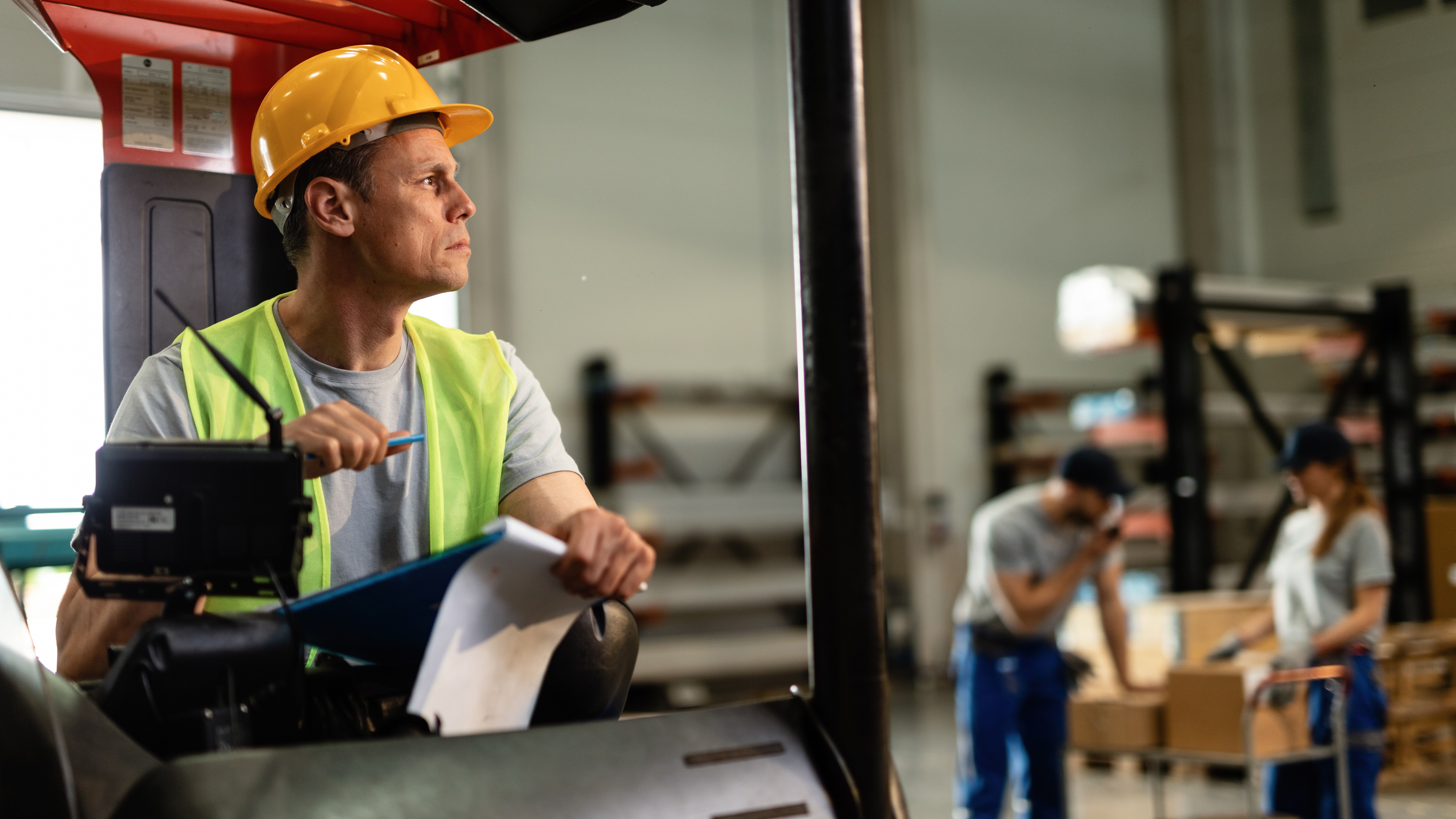 forklift-driver-going-through-paperwork-thinking-something-while-working-distribution-warehouse.jpg